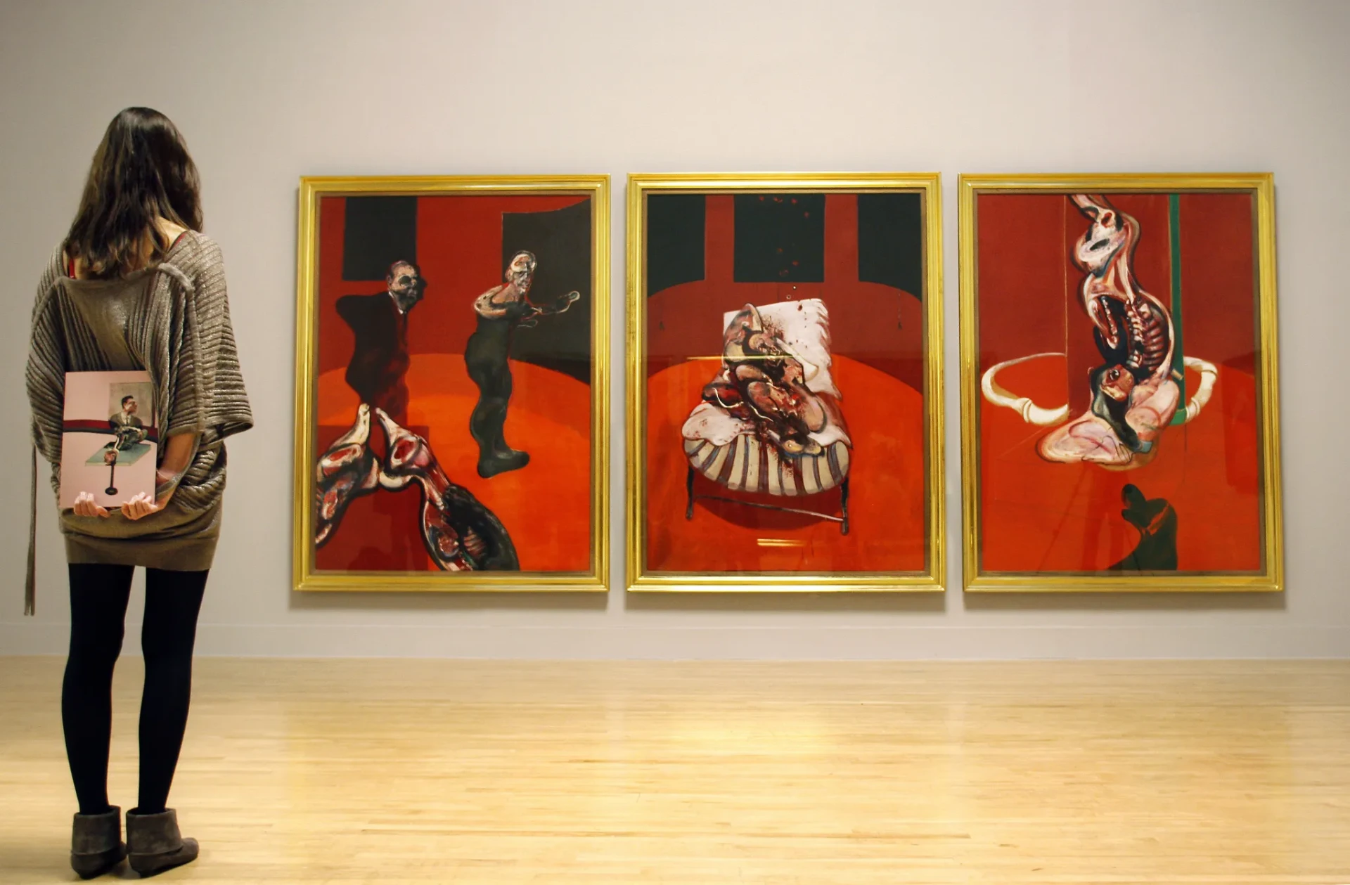 Francis Bacon — visitor viewing a triptych at the retrospective